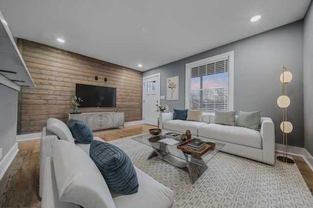 living room with hardwood / wood-style floors and wooden walls