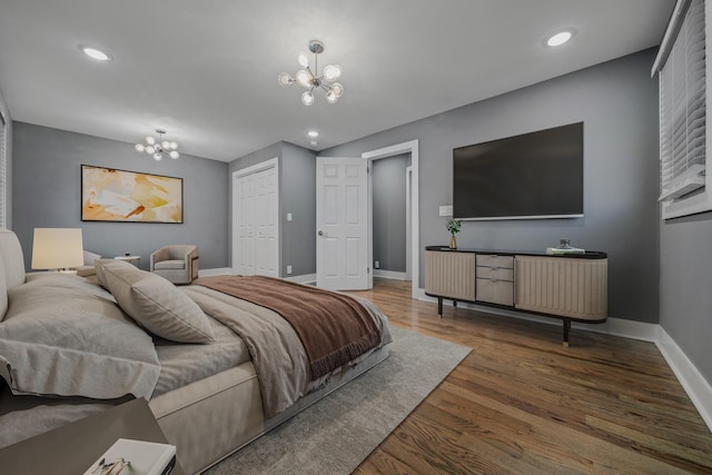 bedroom featuring a chandelier, dark hardwood / wood-style floors, and a closet