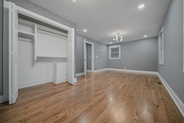 unfurnished bedroom featuring a closet, light hardwood / wood-style flooring, and an inviting chandelier