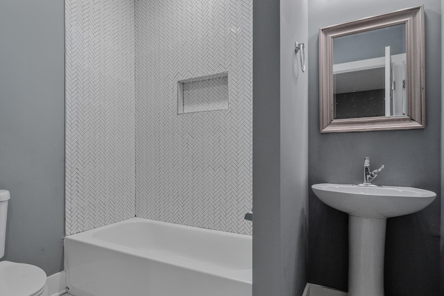 bathroom featuring toilet and tiled shower / bath