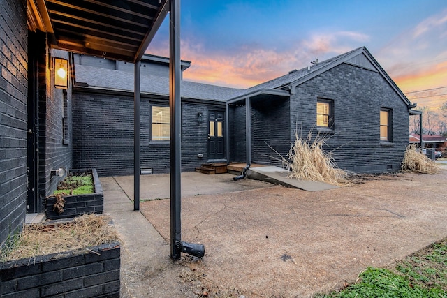 back house at dusk with a patio