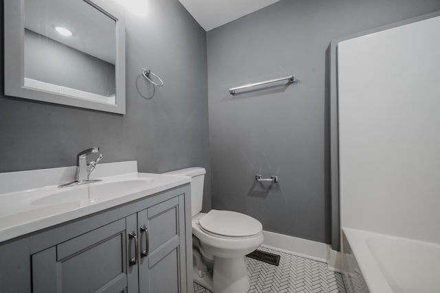 bathroom featuring a washtub, vanity, tile patterned floors, and toilet