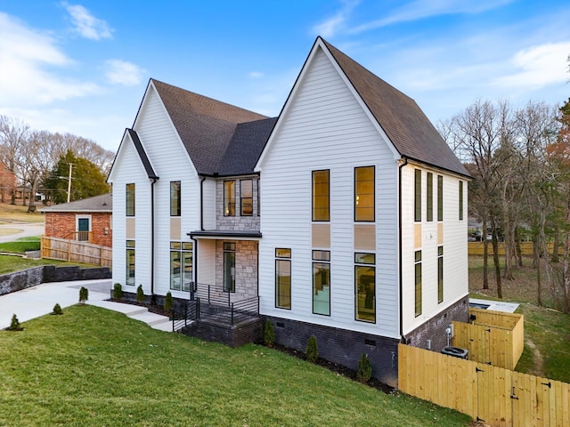 view of front of house featuring crawl space, fence, a front lawn, and roof with shingles