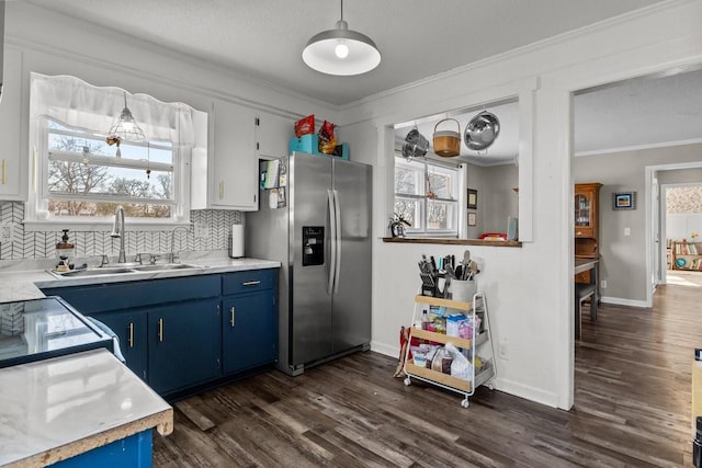 kitchen featuring blue cabinetry, stainless steel refrigerator with ice dispenser, ornamental molding, and sink