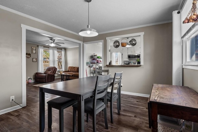 dining room with ceiling fan, dark hardwood / wood-style flooring, a textured ceiling, and ornamental molding