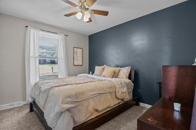 carpeted bedroom with a textured ceiling and ceiling fan