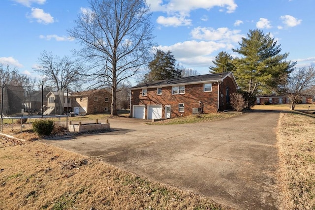 view of home's exterior with a garage and a trampoline