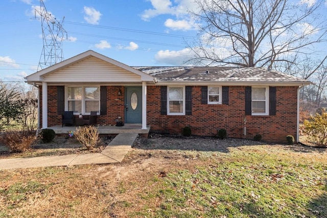 ranch-style home featuring a front lawn and covered porch