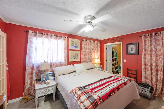 bedroom featuring hardwood / wood-style flooring, ceiling fan, crown molding, and a textured ceiling