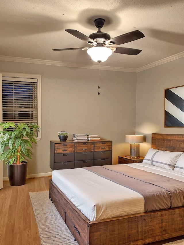 bedroom with crown molding, light hardwood / wood-style flooring, a textured ceiling, and ceiling fan