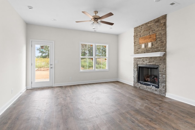 unfurnished living room featuring plenty of natural light, dark hardwood / wood-style floors, a fireplace, and ceiling fan