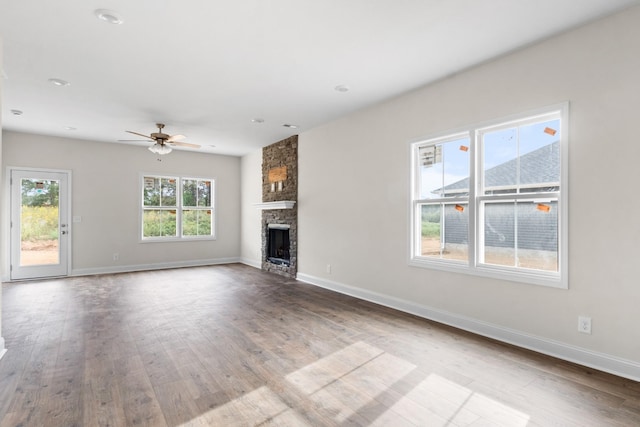 unfurnished living room with ceiling fan, a fireplace, and light hardwood / wood-style floors