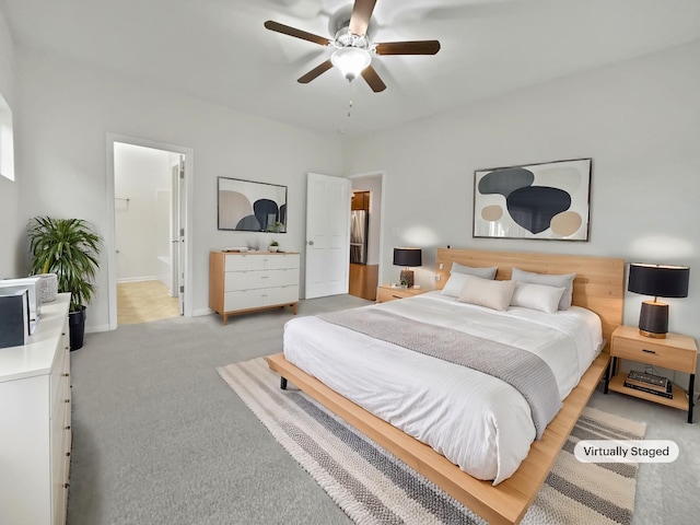 bedroom featuring carpet flooring, ensuite bathroom, and ceiling fan