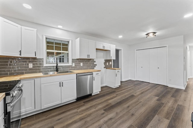 kitchen featuring wooden counters, appliances with stainless steel finishes, dark hardwood / wood-style flooring, sink, and white cabinetry