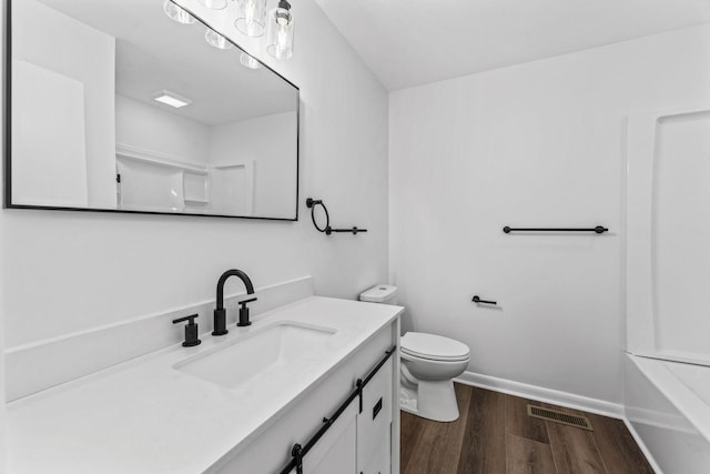 bathroom with vanity, hardwood / wood-style flooring, and toilet