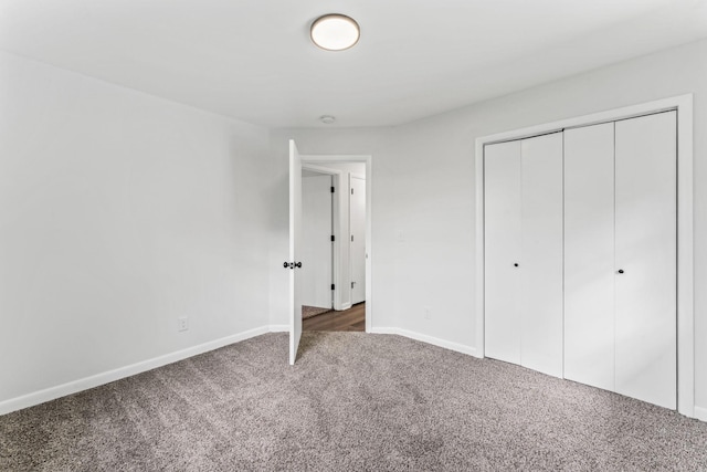 unfurnished bedroom featuring dark colored carpet and a closet