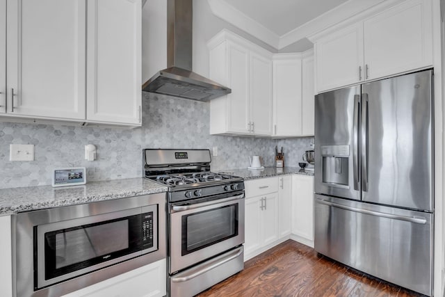 kitchen featuring white cabinets, wall chimney exhaust hood, light stone countertops, and stainless steel appliances