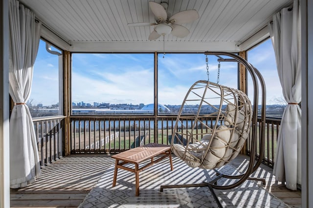 sunroom / solarium featuring ceiling fan and a water view