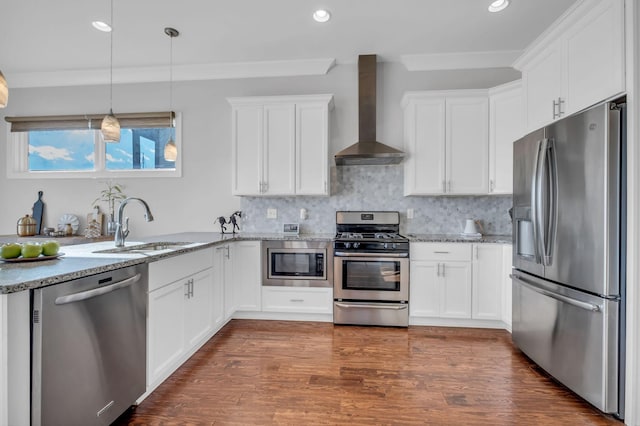 kitchen featuring tasteful backsplash, white cabinetry, wall chimney exhaust hood, and appliances with stainless steel finishes