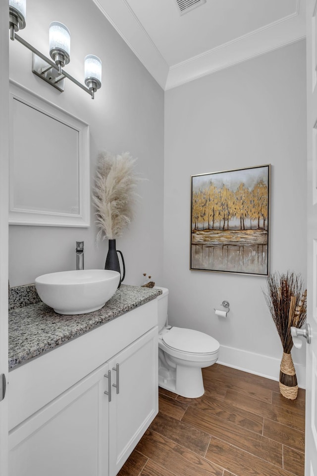 bathroom with vanity, toilet, and crown molding