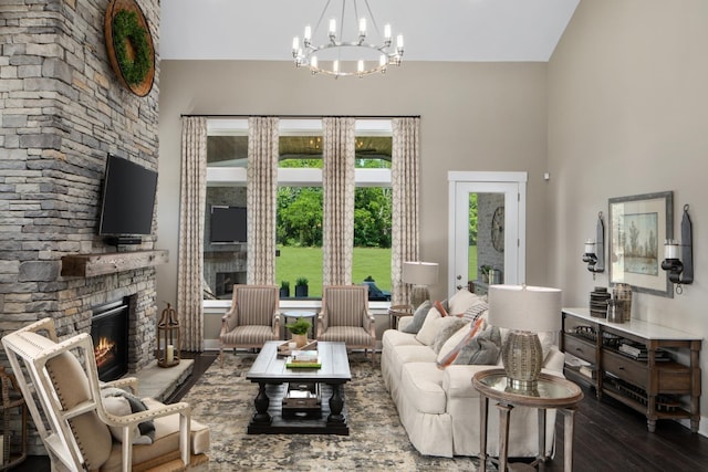 living room featuring a fireplace, wood-type flooring, and a chandelier