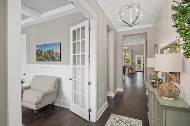 hallway featuring dark wood-type flooring, coffered ceiling, crown molding, beam ceiling, and a chandelier