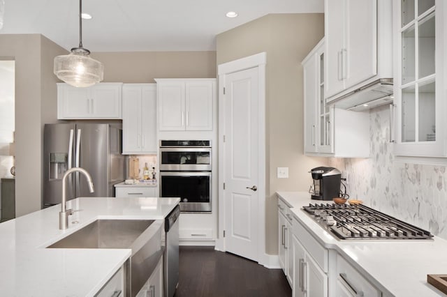 kitchen with white cabinets, pendant lighting, stainless steel appliances, and sink