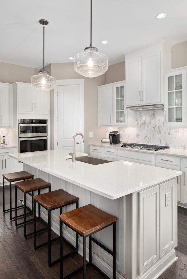 kitchen featuring a breakfast bar area, decorative backsplash, and a large island