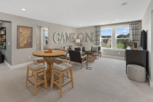 dining space featuring light carpet