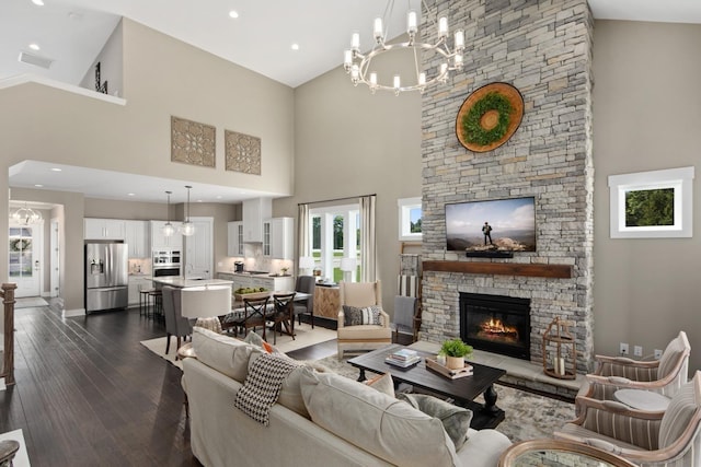 living room featuring a fireplace, a high ceiling, a chandelier, and dark wood-type flooring