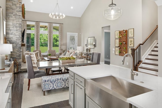 kitchen with dark hardwood / wood-style flooring, sink, high vaulted ceiling, and decorative light fixtures