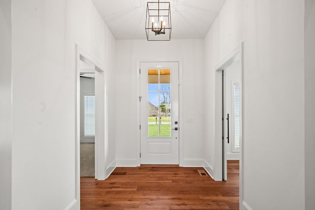 foyer entrance with hardwood / wood-style floors and a chandelier