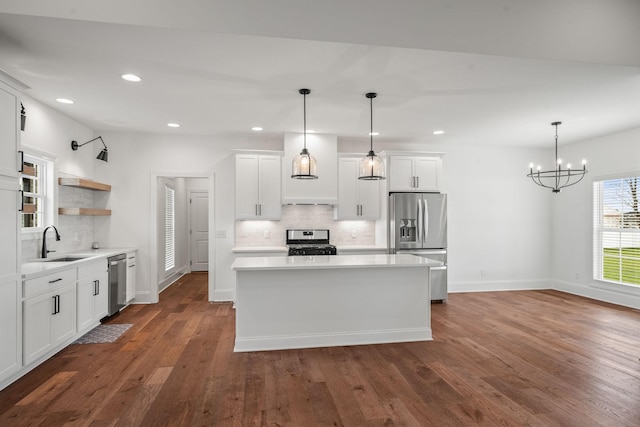 kitchen featuring decorative light fixtures, stainless steel appliances, and white cabinetry