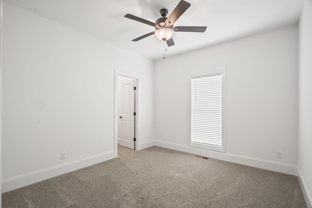 spare room featuring light colored carpet and ceiling fan