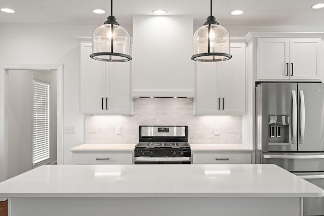 kitchen with a center island, stainless steel appliances, white cabinetry, and hanging light fixtures