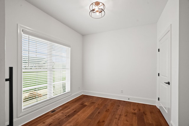 unfurnished room featuring dark hardwood / wood-style flooring and a wealth of natural light