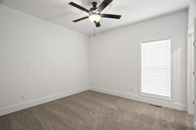 carpeted spare room with plenty of natural light and ceiling fan