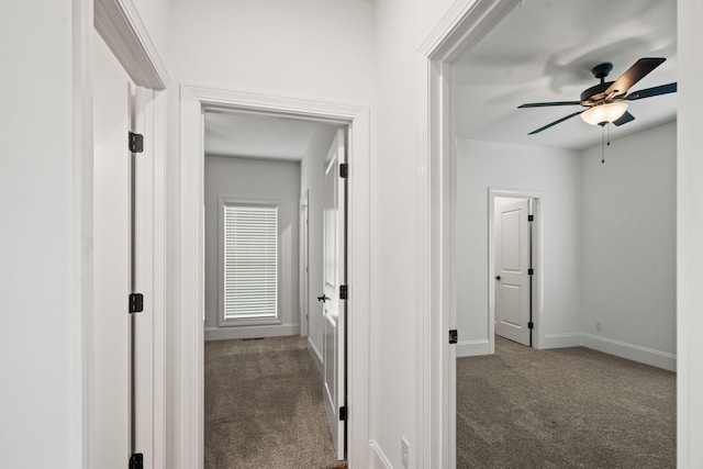 hall with dark colored carpet