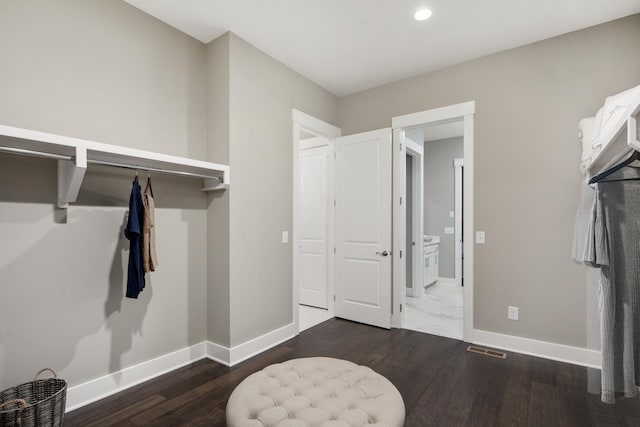 walk in closet with dark hardwood / wood-style floors