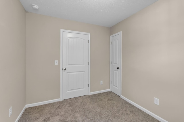 carpeted empty room with a textured ceiling