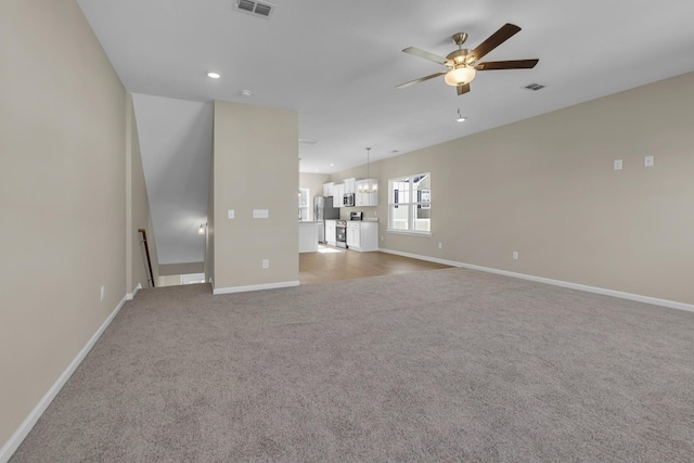 unfurnished living room featuring carpet flooring and ceiling fan