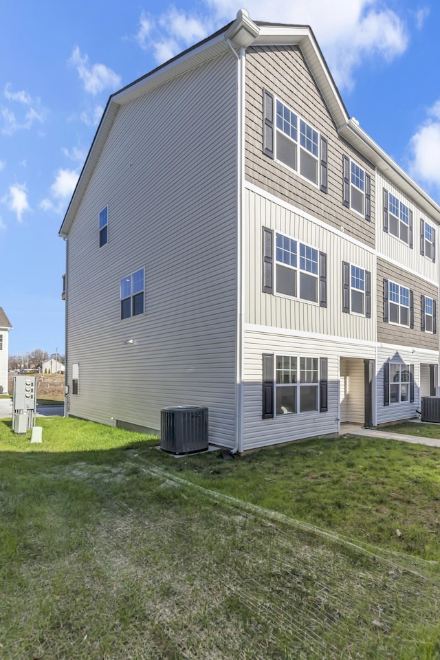 view of property exterior with a lawn and central AC unit