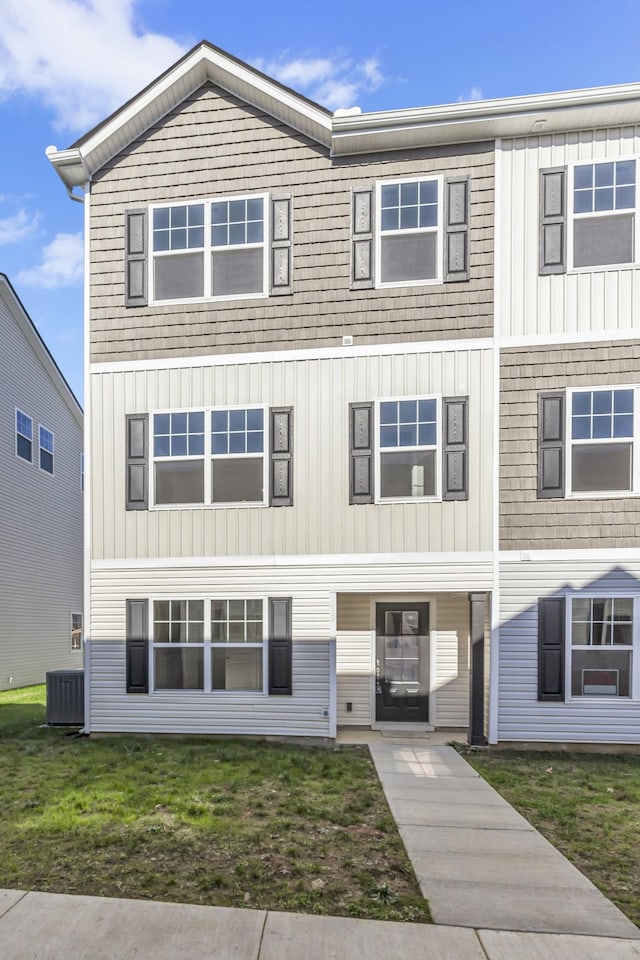 view of front of property with a front lawn and cooling unit