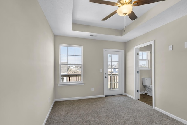 interior space featuring ceiling fan, a raised ceiling, and carpet floors