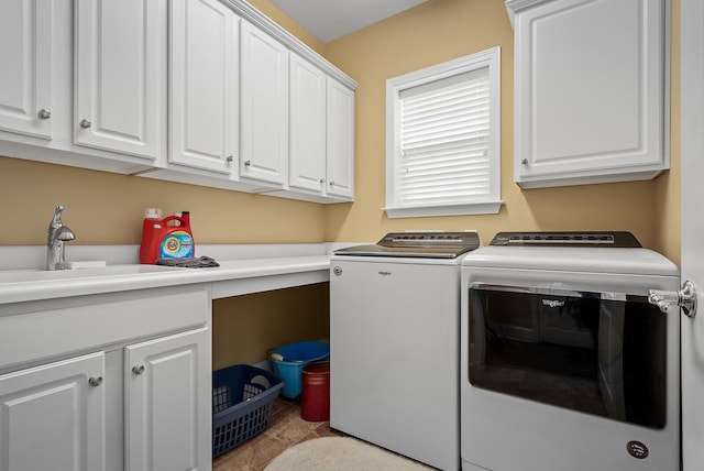 clothes washing area with cabinets, washer and clothes dryer, and sink