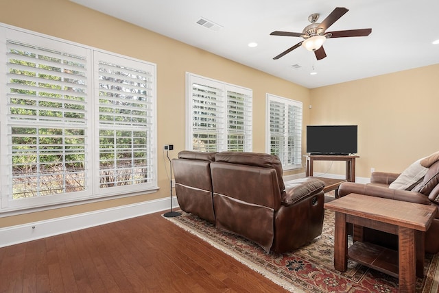 living room featuring ceiling fan, a healthy amount of sunlight, and dark hardwood / wood-style floors