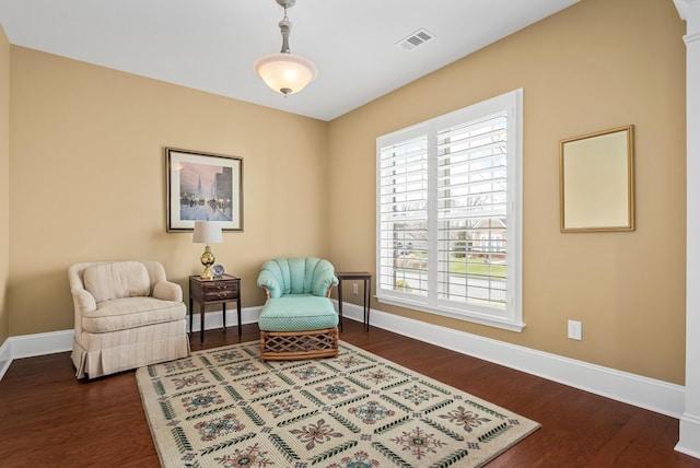 living area with a wealth of natural light and dark hardwood / wood-style flooring