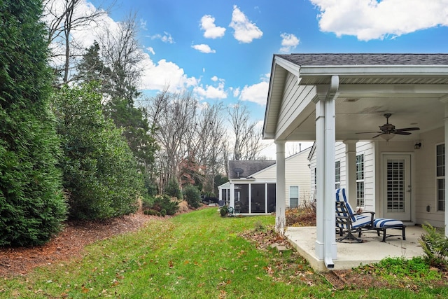 view of yard with a sunroom, ceiling fan, and a patio