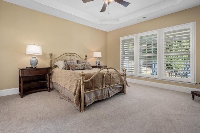 bedroom featuring carpet flooring, a tray ceiling, and ceiling fan