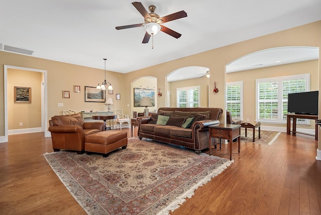 living room with plenty of natural light, hardwood / wood-style floors, and ceiling fan with notable chandelier